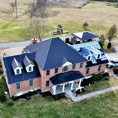 Standing seam metal roof installation on a brick colonial home